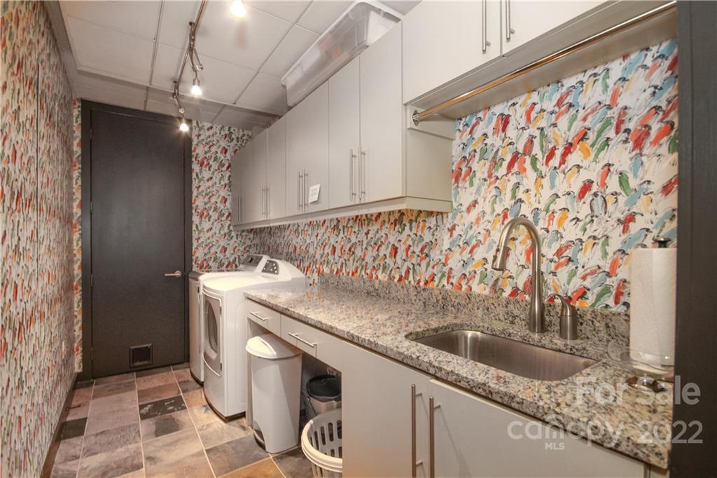 139 South Tryon Street Charlotte, NC 28202 - Photo 47 of 48 a bathroom with a granite countertop sink a washer and dryer
