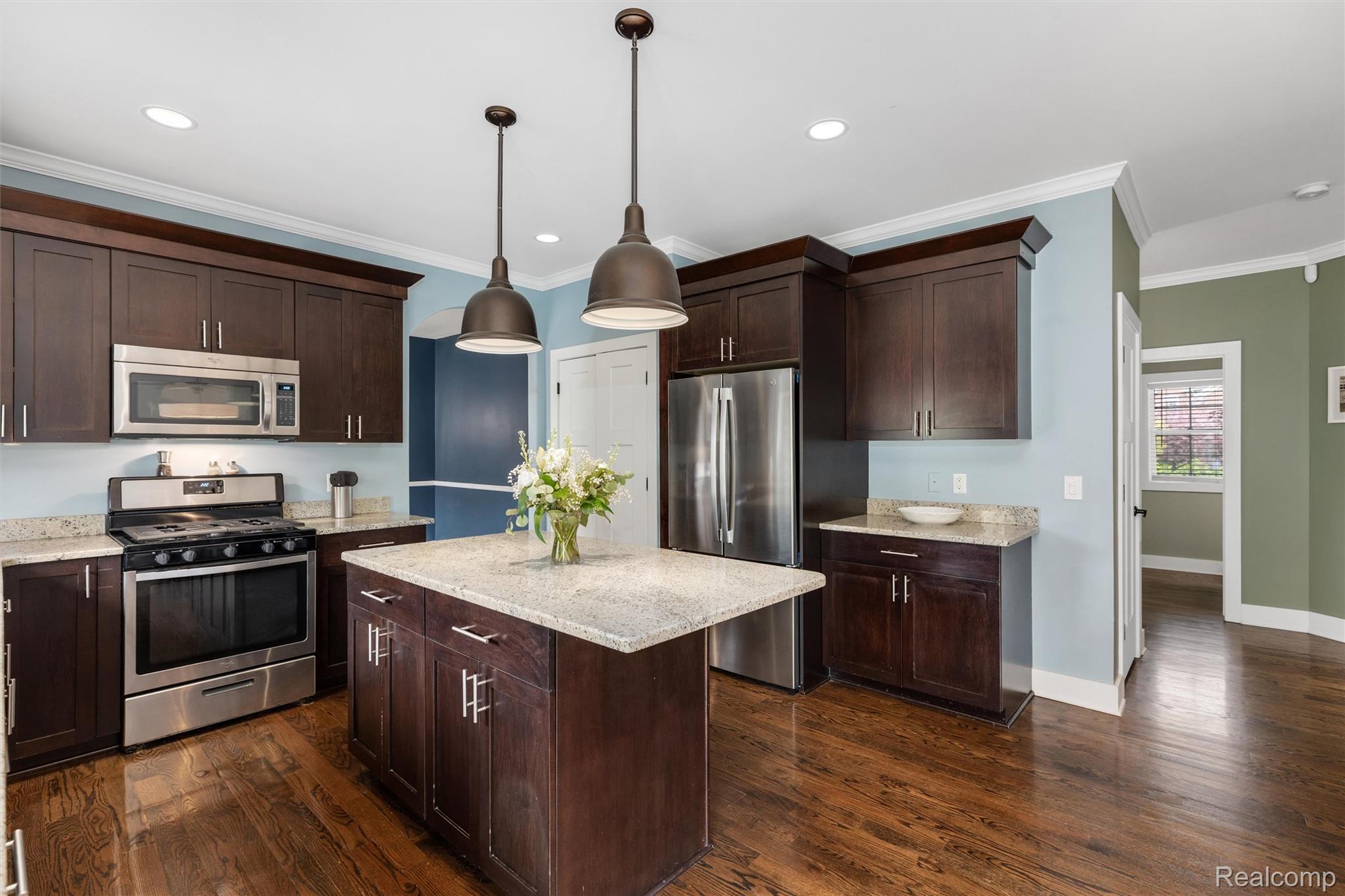 1016 West Snell Road Rochester, MI 48306 - Photo 14 of 35 Kitchen featuring wood-finish flooring and a central island with a light-toned countertop