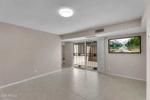 an empty room with floor to ceiling window and wooden floor