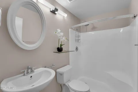 a bathroom with a sink a toilet and shower