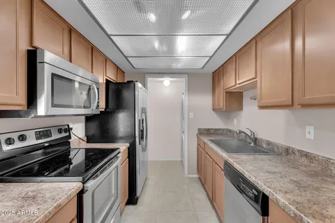 a kitchen with stainless steel appliances granite countertop a sink a stove and a refrigerator