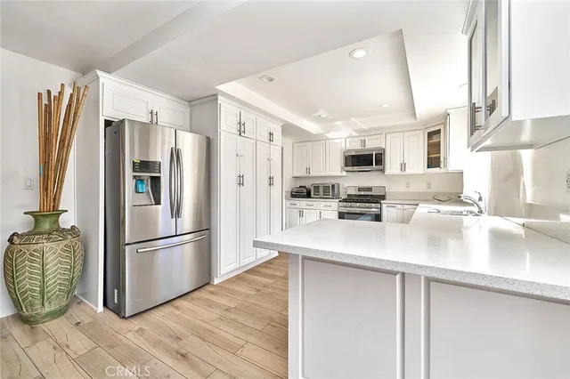 a kitchen with stainless steel appliances granite countertop a refrigerator a stove a microwave and a refrigerator