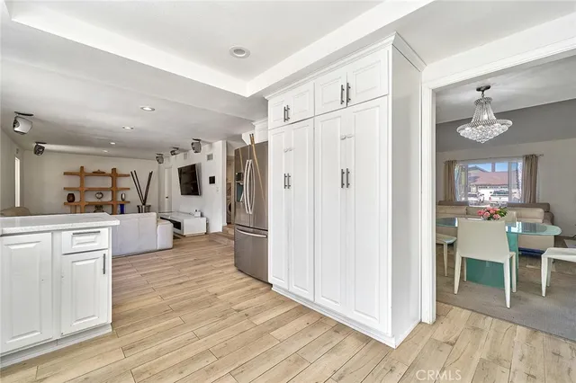 a large white kitchen with cabinets and wooden floor