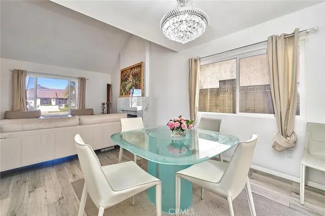 a dining room with wooden floor and a chandelier