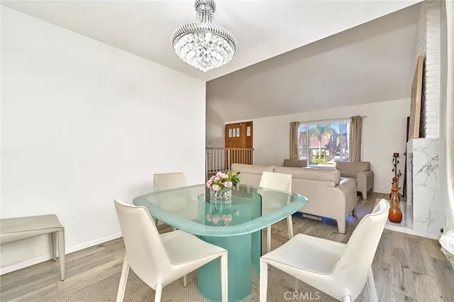a dining room with furniture a chandelier and wooden floor