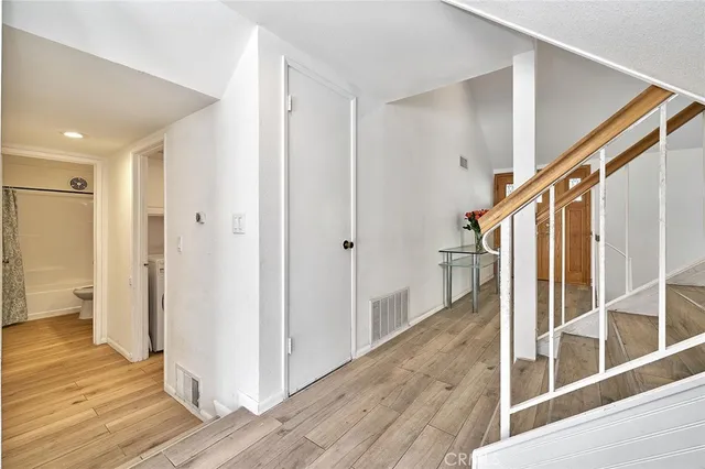 a view of a hallway with wooden floor and staircase