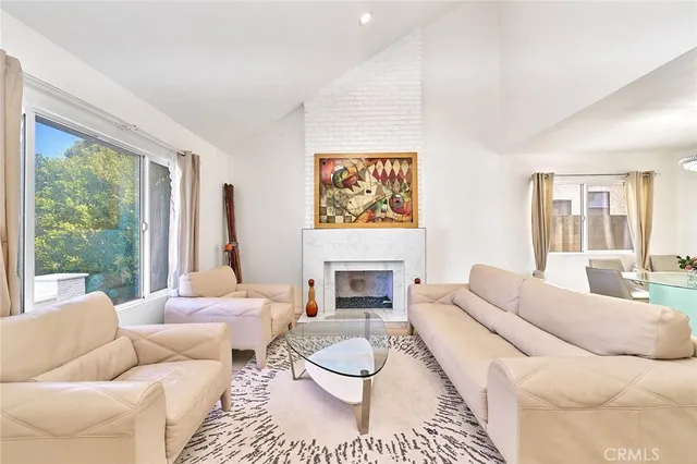 a living room with furniture a fireplace and a large window
