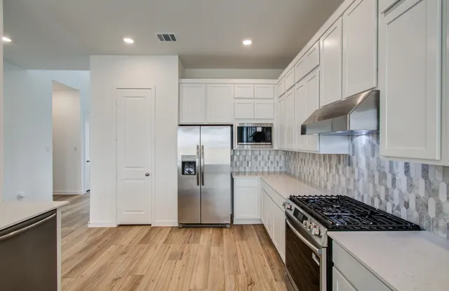 a kitchen with granite countertop a stove and a refrigerator