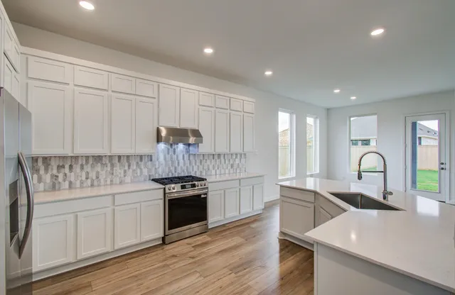 a kitchen with granite countertop white cabinets and appliances