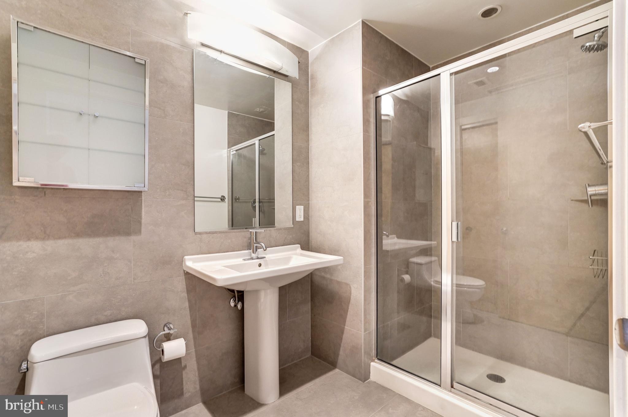 1133 14th Street Northwest, Unit 809 Washington, DC 20005 - Photo 13 of 27 a bathroom with a sink a toilet and shower