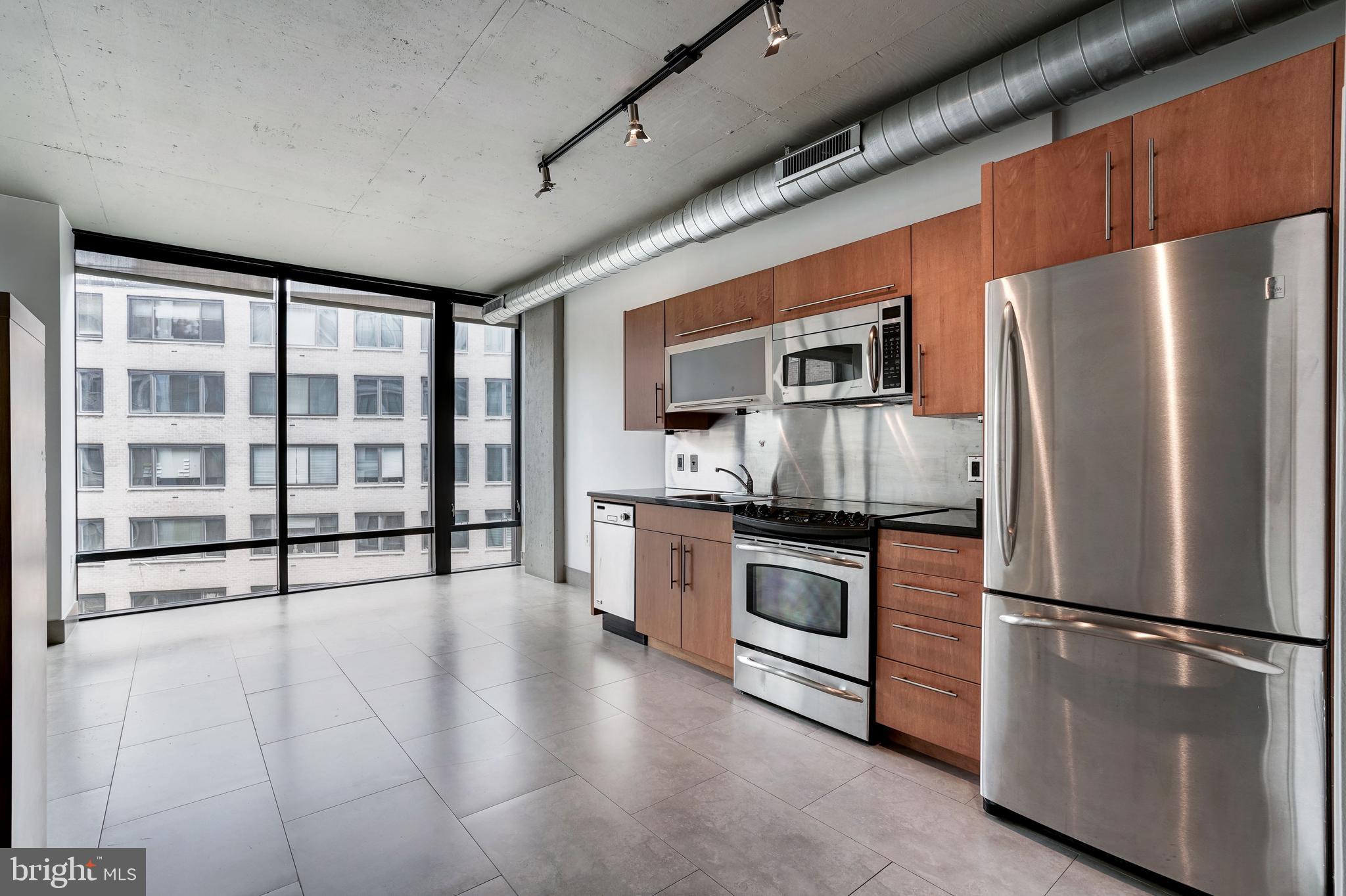 1133 14th Street Northwest, Unit 809 Washington, DC 20005 - Photo 4 of 27 a kitchen with stainless steel appliances a refrigerator sink and microwave