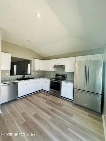 a large kitchen with a stove top oven and refrigerator