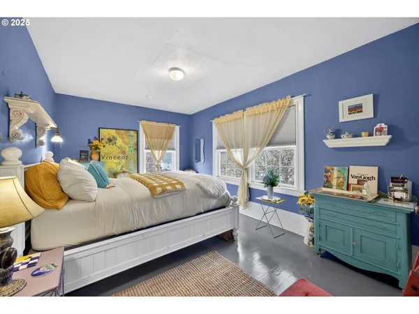 a bedroom with a bed dresser and window