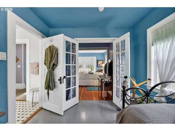 a living room with furniture a flat screen tv and a refrigerator