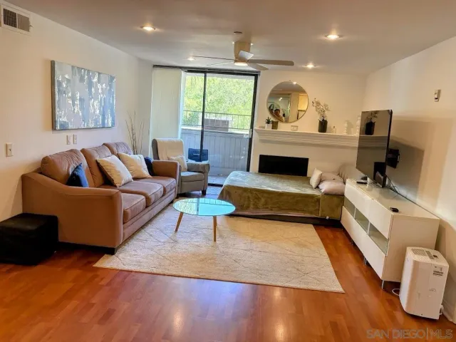 a living room with furniture fireplace and a large window