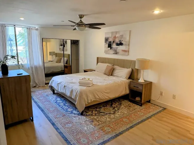 a bedroom with a bed and wooden floor