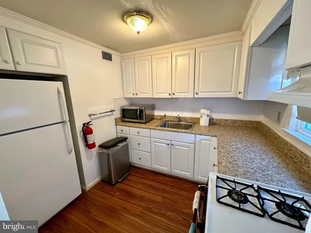 a kitchen with stainless steel appliances granite countertop a refrigerator sink and stove