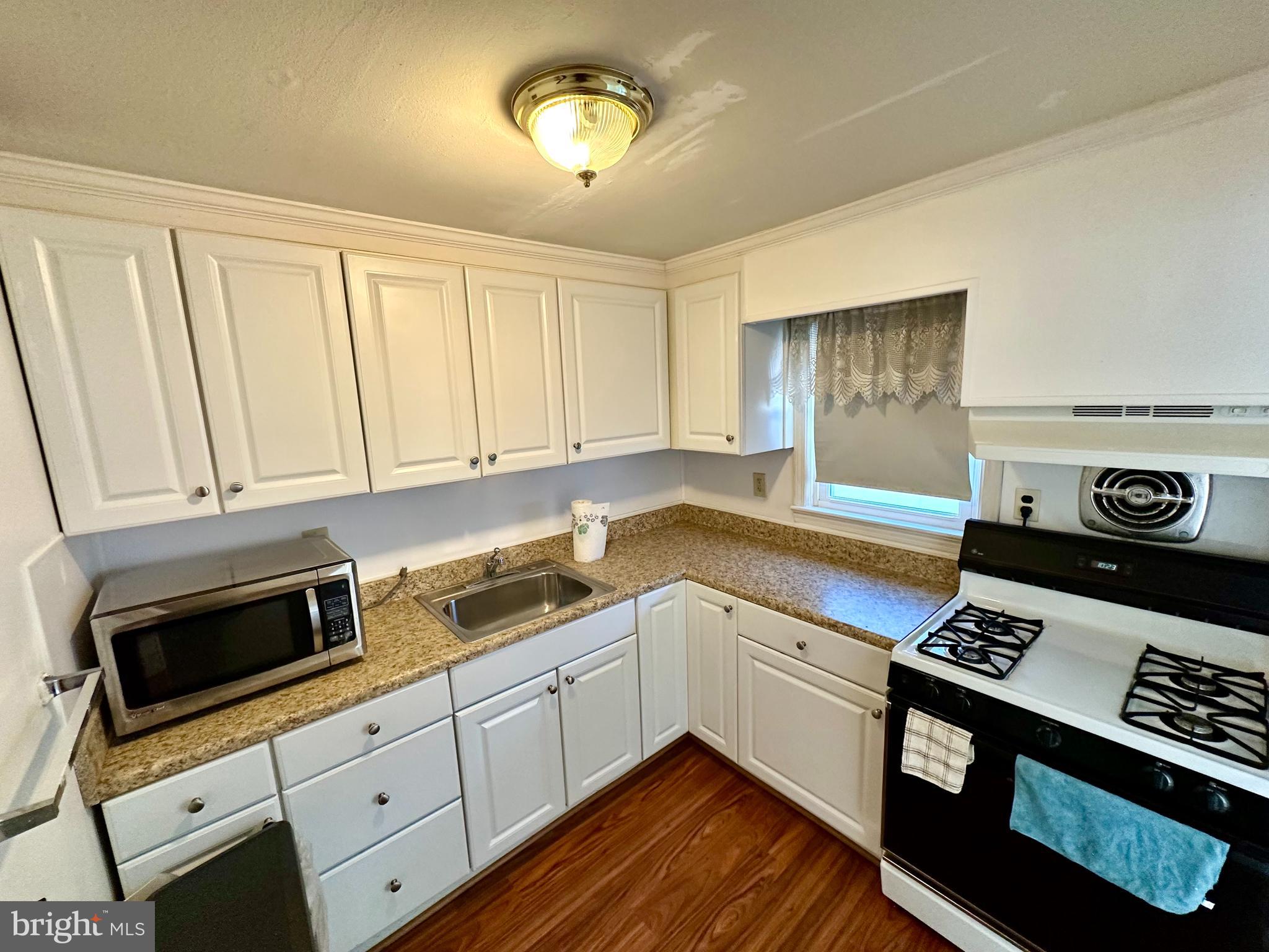 23 Vincent Avenue, Unit 1F Hamilton, NJ 08619 - Photo 3 of 10 a kitchen with stainless steel appliances a stove a microwave and cabinets