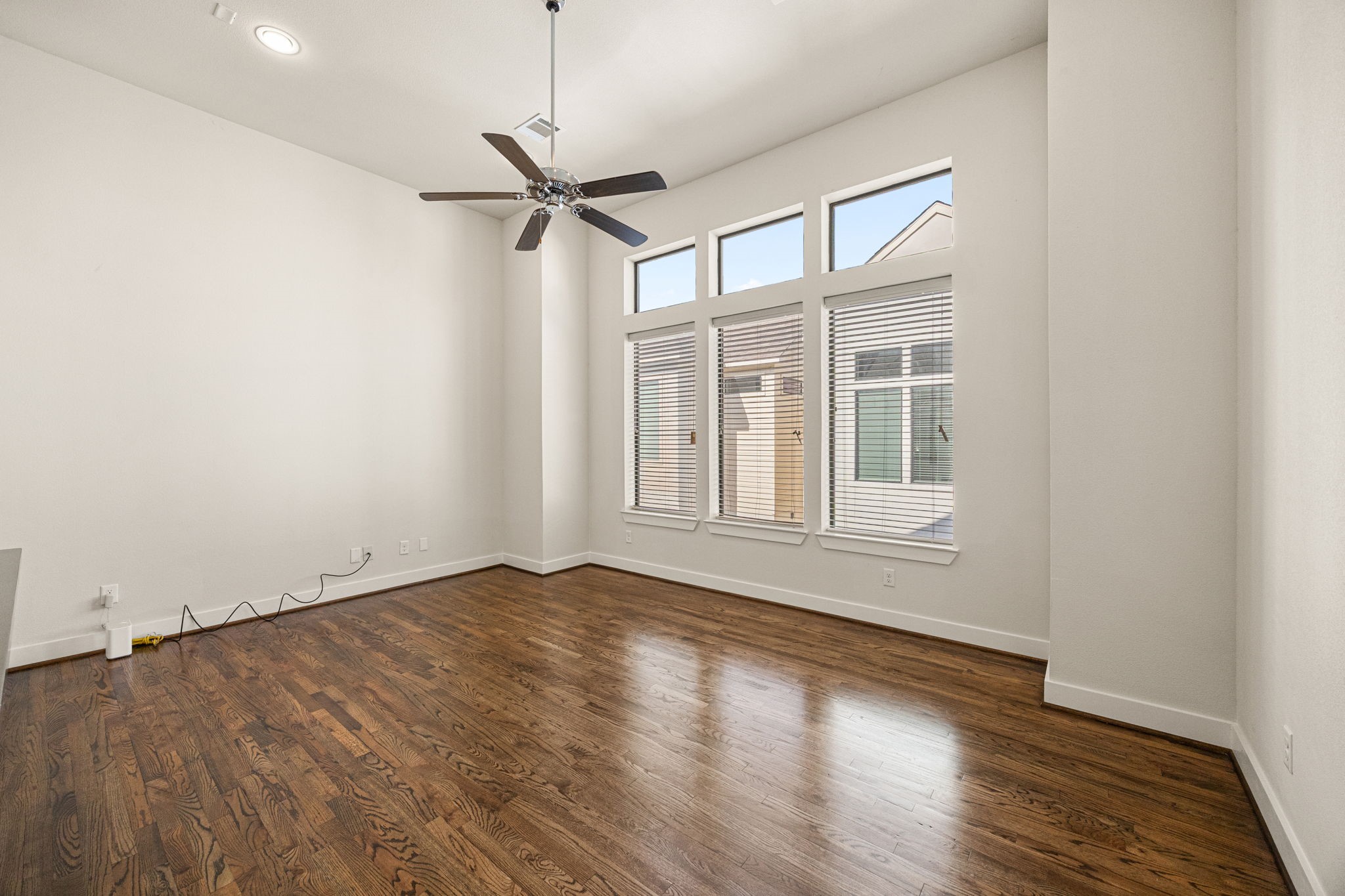 3945 Tulane Street Houston, TX 77018 - Photo 9 of 26 an empty room with wooden floor fan and windows