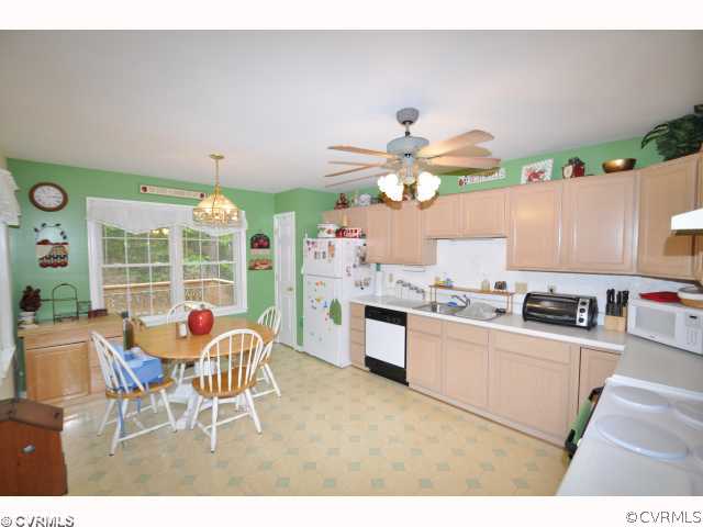 2525 Brookforest Road Midlothian, VA 23112 - Photo 2 of 11 a kitchen with stainless steel appliances kitchen island granite countertop a table and chairs in it