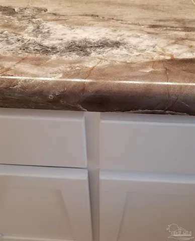 a bathroom with a granite countertop sink a toilet and mirror