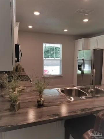 a kitchen with kitchen island granite countertop a sink and a window