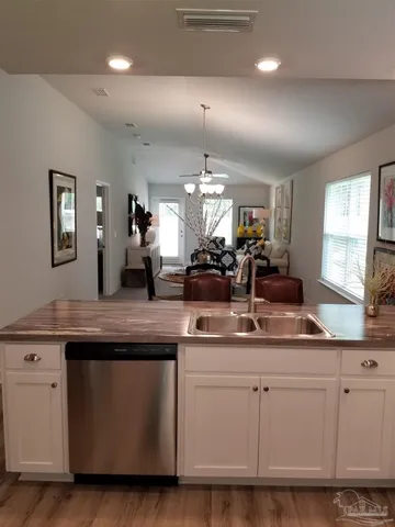 a kitchen with white cabinets and sink