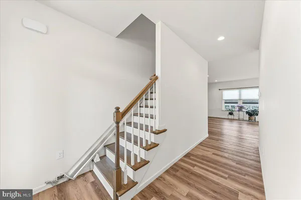 a view of a hallway with wooden floor and staircase