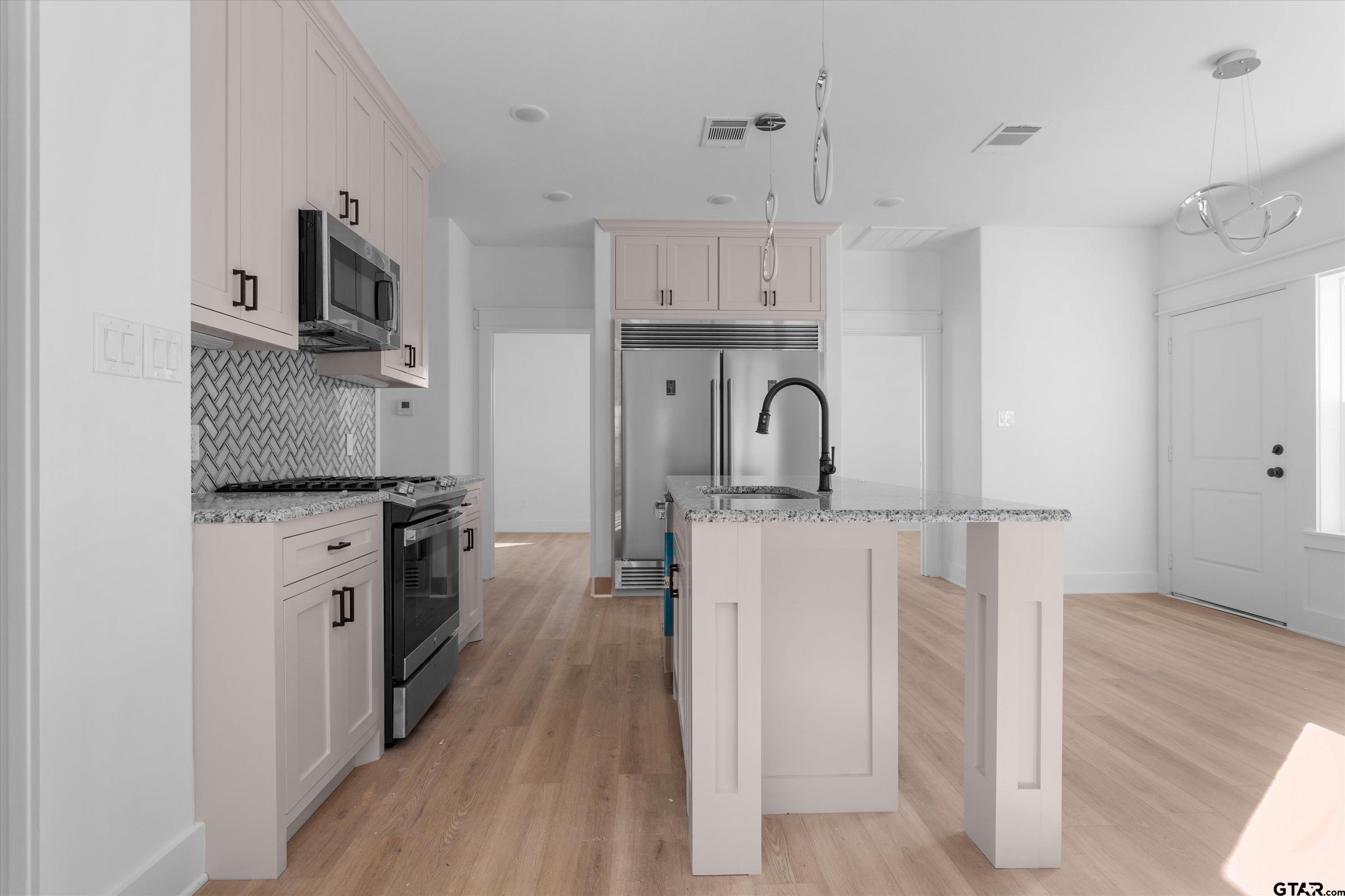 3026 Rose Tyler, TX 75701 - Photo 12 of 25 a kitchen with white cabinets and stainless steel appliances