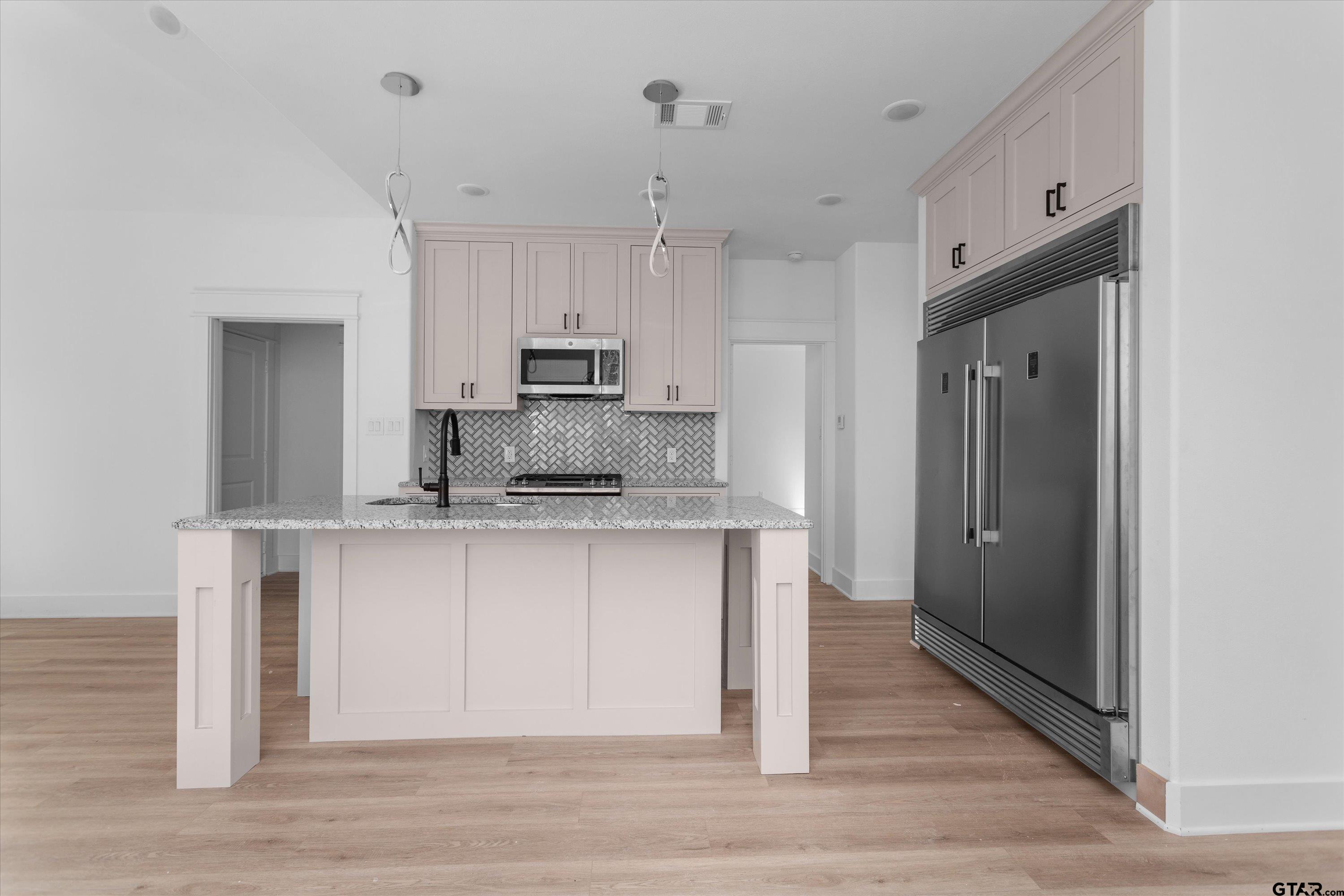 3026 Rose Tyler, TX 75701 - Photo 8 of 25 a kitchen with kitchen island white cabinets and refrigerator