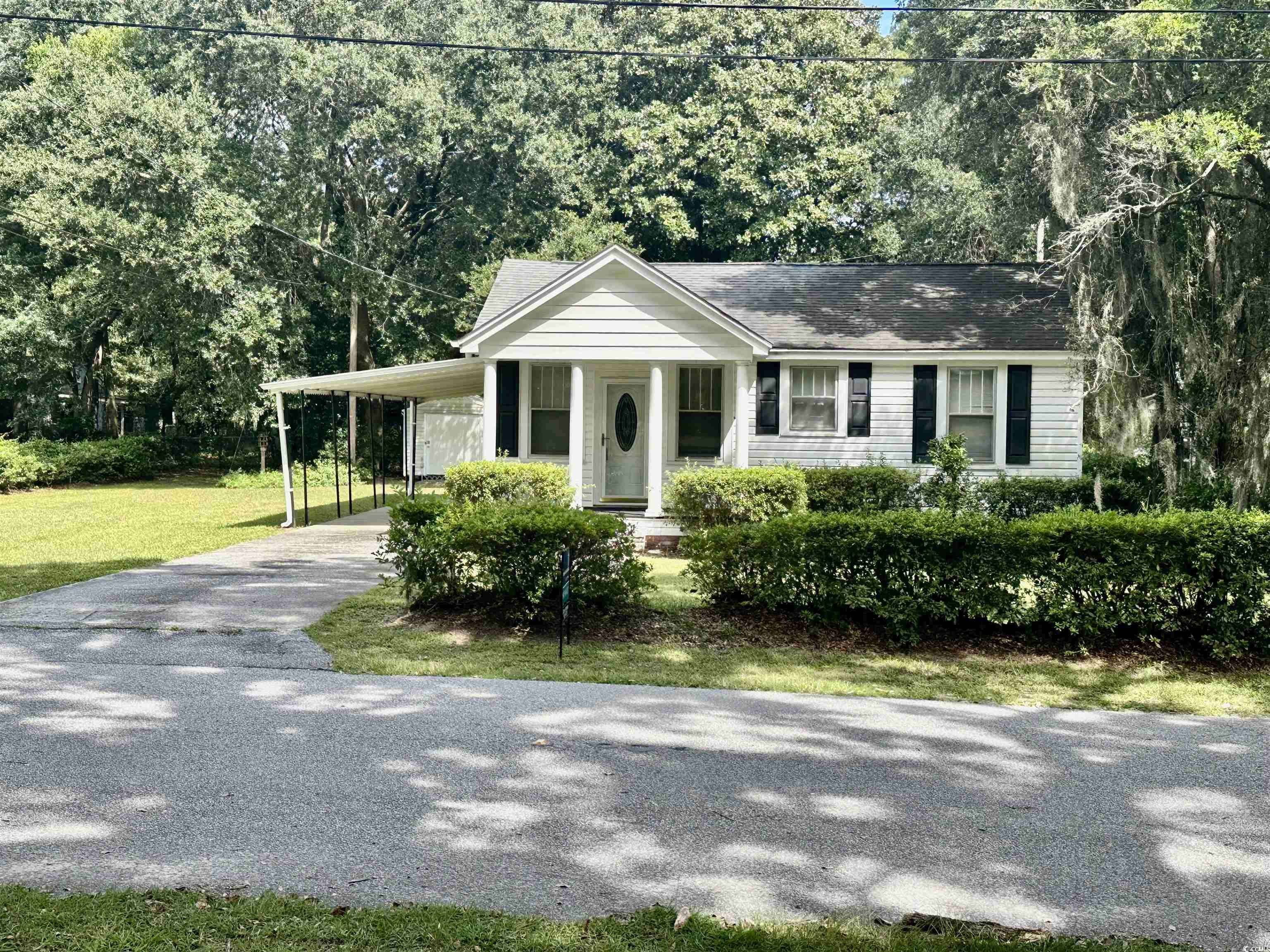 1357 Moss Street Georgetown, SC 29440 - Photo 1 of 13 View of front facade with a porch, a carport, driveway, and a front lawn