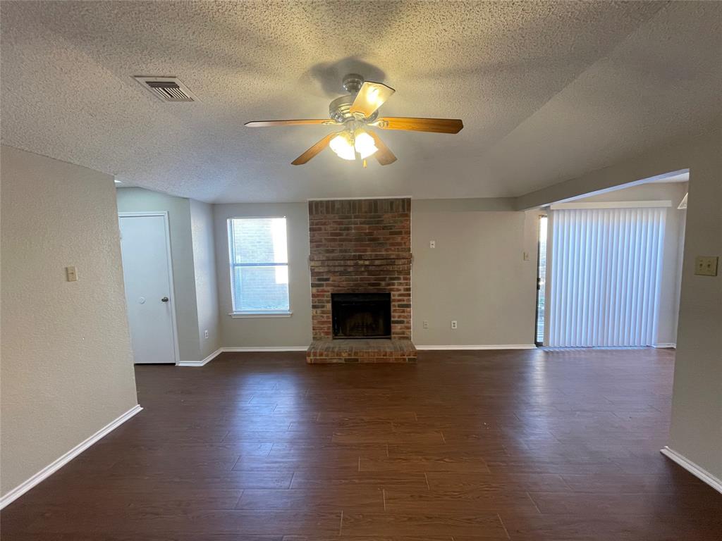 226 Wilderness Trail Mesquite, TX 75149 - Photo 3 of 12 a view of an empty room with wooden floor fireplace and a window