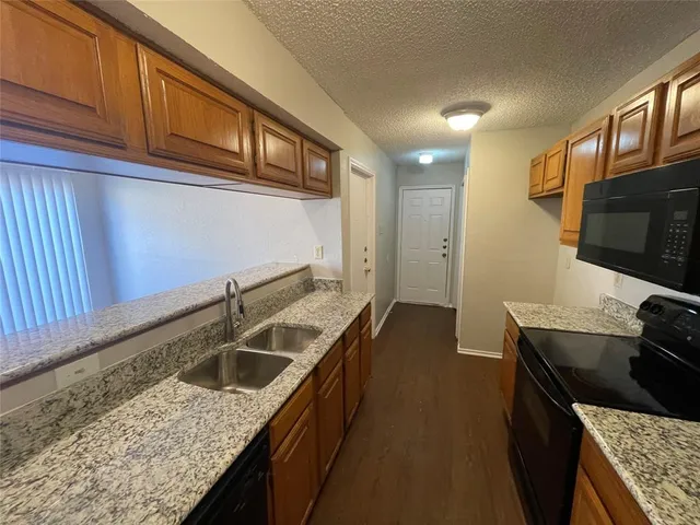 a kitchen with granite countertop stainless steel appliances window a sink and a counter space
