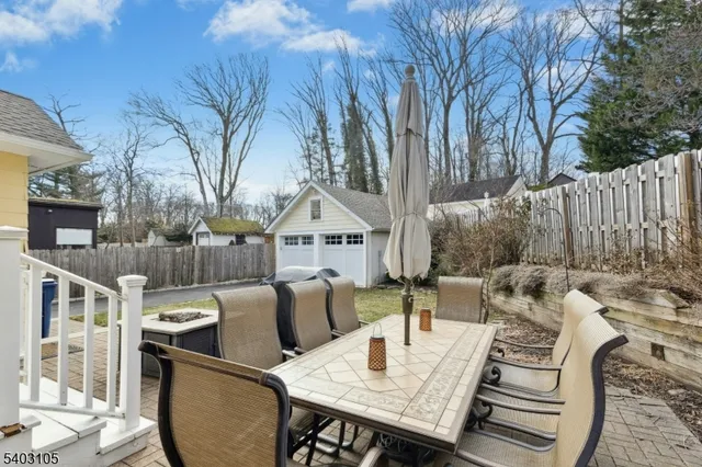 a view of a patio with couches table and chairs and wooden fence