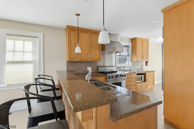 a kitchen with granite countertop a sink a stove and a wooden floor