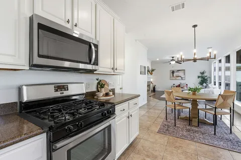 a kitchen with stainless steel appliances kitchen island granite countertop a stove a sink and a microwave