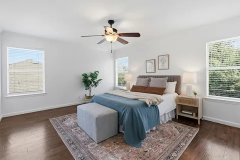 a bedroom with a large bed and wooden floor