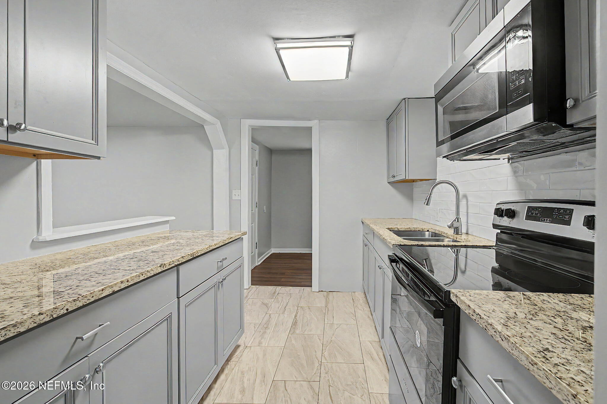 2625 Kohn Road Jacksonville, FL 32210 - Photo 34 of 34 a kitchen with stainless steel appliances granite countertop a stove a sink and a microwave
