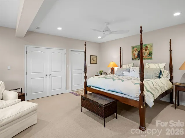 a spacious bedroom with a bed and a chandelier