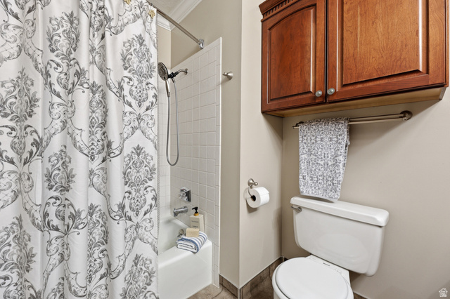 2342 Charros Road Sandy, UT 84092 - Photo 27 of 94 Bathroom featuring a white tub with subway tile surround, chrome shower fixtures, crown molding, a built-in wood-finish cabinet, and a white toilet