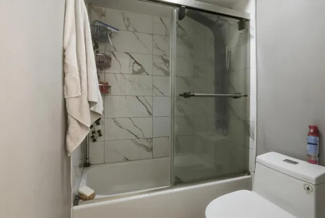 a bedroom with a bed and a large mirror on the dresser