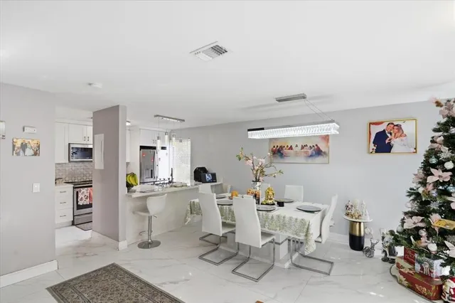 a kitchen with stainless steel appliances granite countertop a stove a microwave a refrigerator a cabinets and a stove