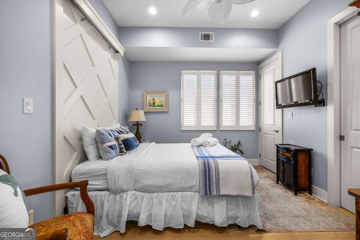 8 18th Street Tybee Island, GA 31328 - Photo 33 of 50 a bedroom with a bed a flat screen tv and a window