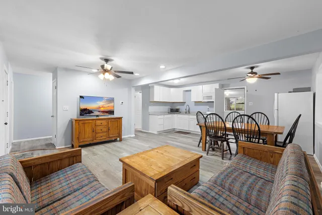 a living room with furniture kitchen view and a table