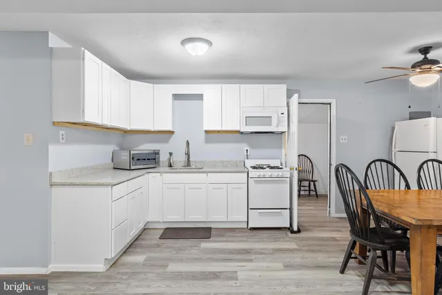 a kitchen with white cabinets and white appliances