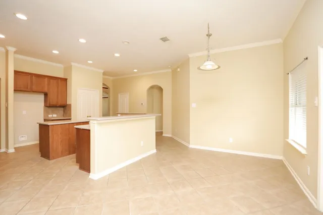 a view of kitchen with kitchen island stainless steel appliances wooden cabinets and window
