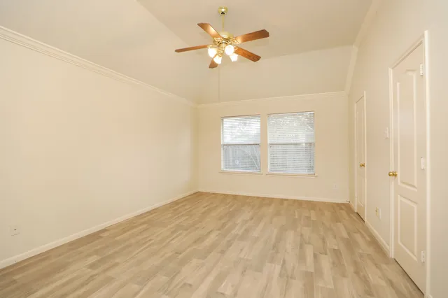 an empty room with a window and a ceiling fan