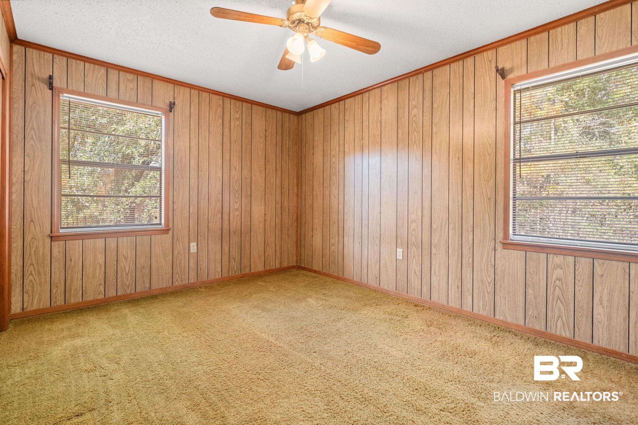 1456 Herman Williams Road Fruitdale, AL 36539 - Photo 14 of 24 Carpeted empty room with a textured ceiling, wooden walls, and ceiling fan