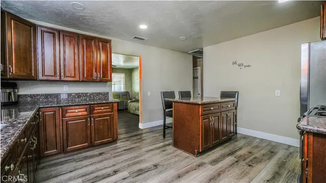 a kitchen with stainless steel appliances granite countertop wooden cabinets a refrigerator and a stove