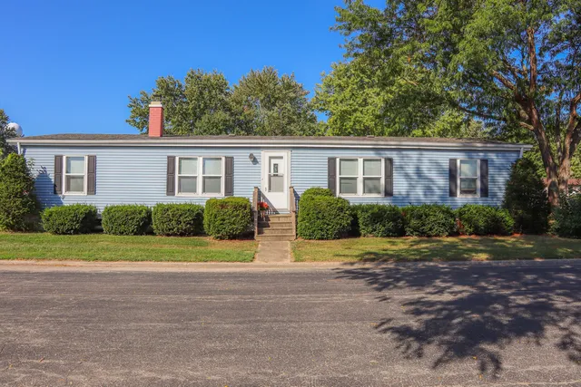 a front view of a house with a yard and trees